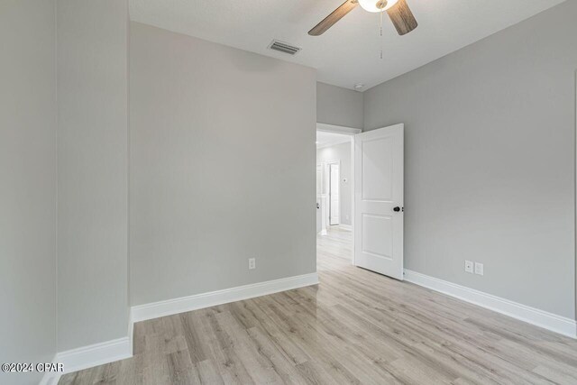 empty room with light hardwood / wood-style floors and ceiling fan