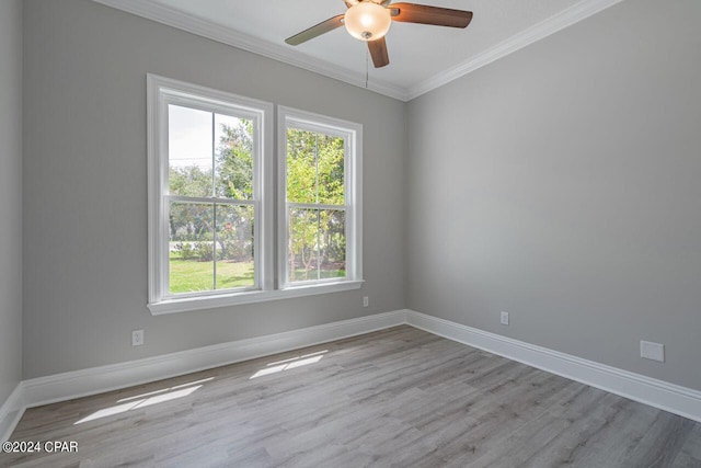 empty room featuring crown molding, ceiling fan, wood-type flooring, and a wealth of natural light