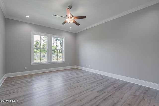 empty room with ornamental molding, light wood-type flooring, and ceiling fan