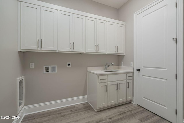 clothes washing area with light hardwood / wood-style floors, sink, cabinets, and hookup for an electric dryer