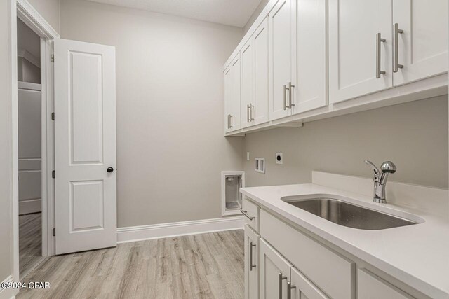 laundry area featuring sink, cabinets, light hardwood / wood-style floors, electric dryer hookup, and washer hookup