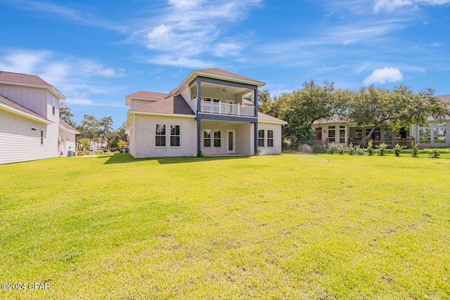 rear view of property with a balcony and a lawn