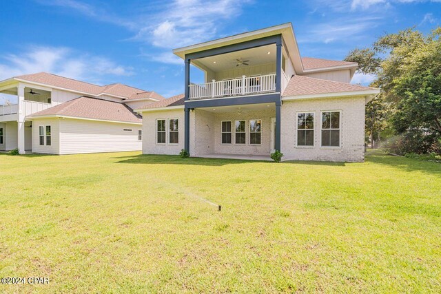 rear view of house featuring a balcony, a yard, and ceiling fan