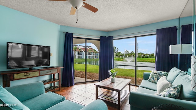 tiled living room with a water view, ceiling fan, and a textured ceiling