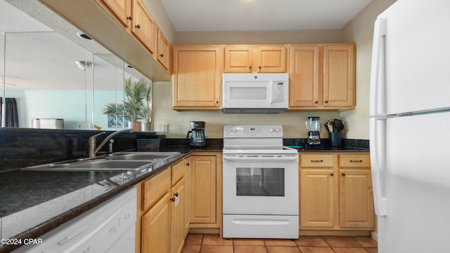 kitchen with dark stone counters, light tile patterned flooring, sink, white appliances, and light brown cabinets