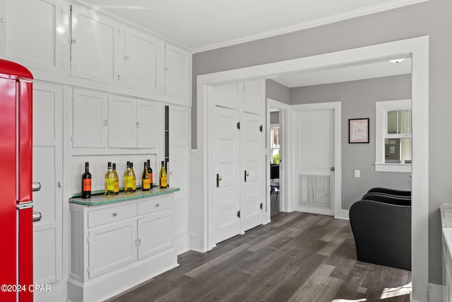 kitchen featuring dark hardwood / wood-style flooring, high end refrigerator, white cabinets, and crown molding