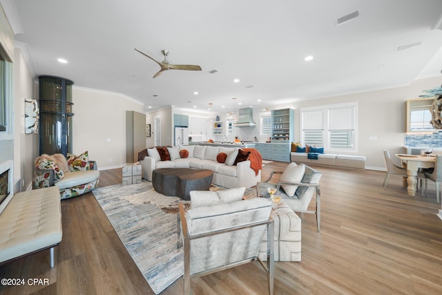 living room featuring crown molding, ceiling fan, and light hardwood / wood-style floors