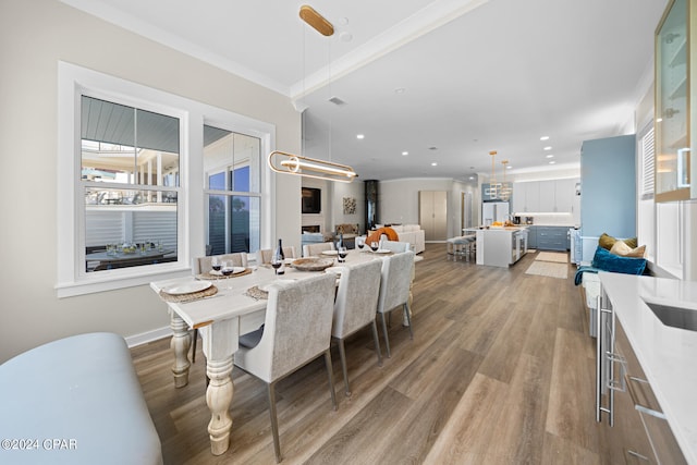 dining area with hardwood / wood-style flooring and crown molding