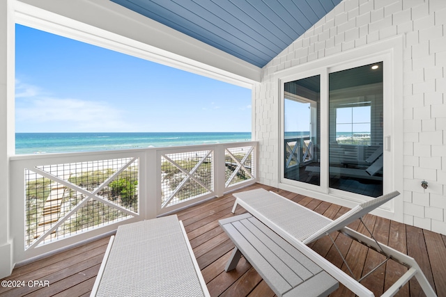 wooden deck featuring a view of the beach and a water view