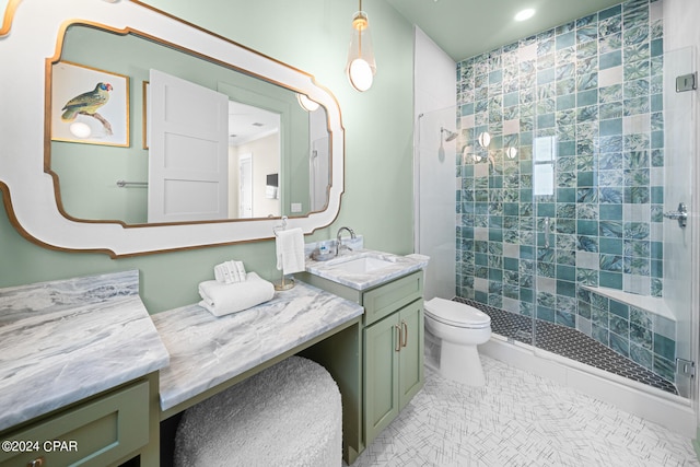 bathroom with vanity, tiled shower, tile patterned floors, and toilet