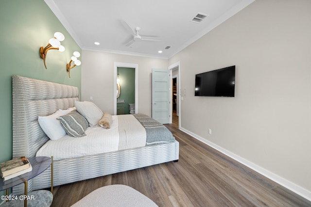 bedroom featuring crown molding, hardwood / wood-style floors, ensuite bath, and ceiling fan