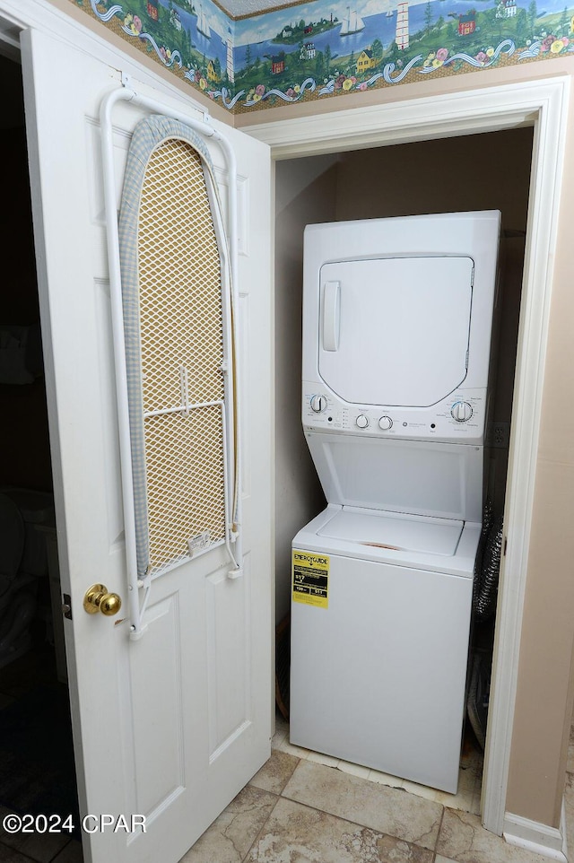 clothes washing area featuring stacked washing maching and dryer