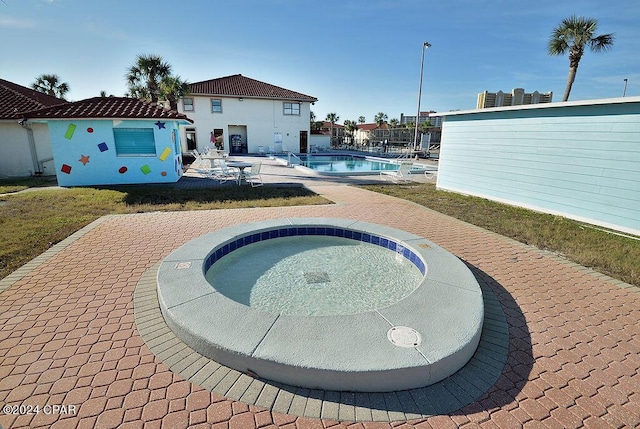 view of pool featuring a hot tub and a patio