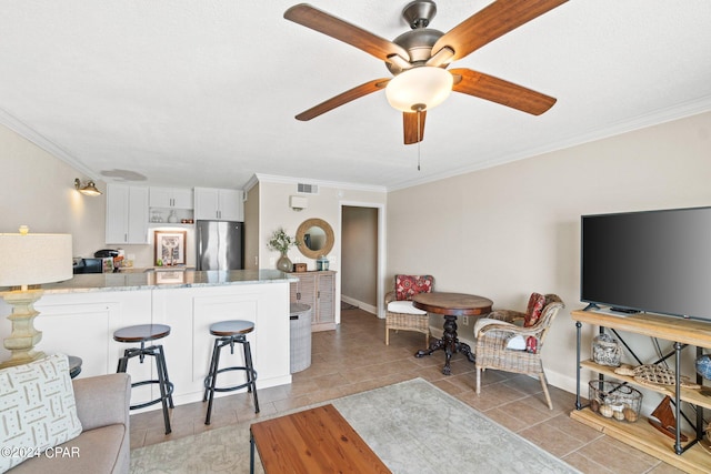 living room featuring light tile patterned flooring, ornamental molding, and ceiling fan