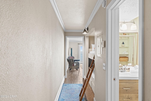 corridor with tile patterned flooring, a textured ceiling, sink, and crown molding