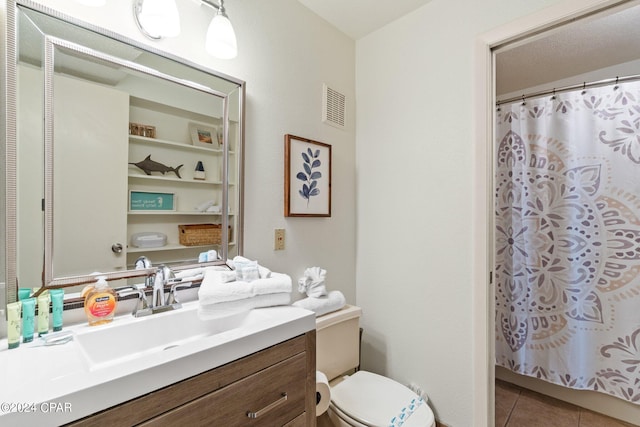 bathroom featuring tile patterned floors, curtained shower, vanity, and toilet