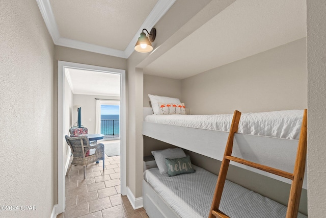 bedroom with a water view, tile patterned floors, and crown molding