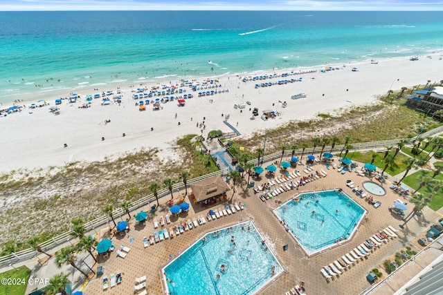 birds eye view of property featuring a water view and a beach view