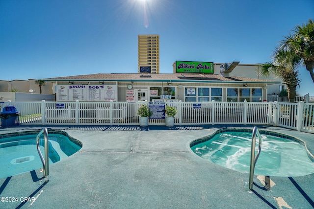 view of swimming pool with a community hot tub