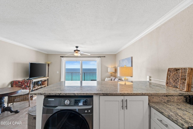 kitchen featuring white cabinetry, a textured ceiling, ceiling fan, washer / dryer, and ornamental molding