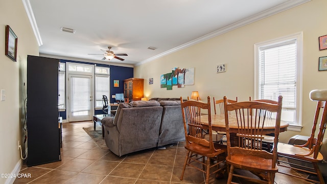 living room featuring ornamental molding, dark tile patterned flooring, a wealth of natural light, and ceiling fan