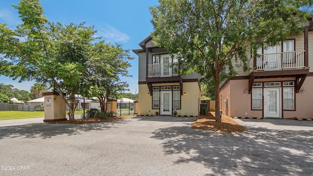 view of front of home with central air condition unit, a balcony, and french doors