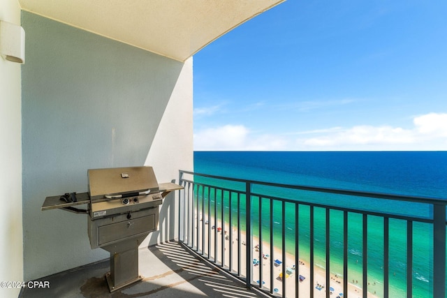 balcony featuring a view of the beach, a water view, and a grill