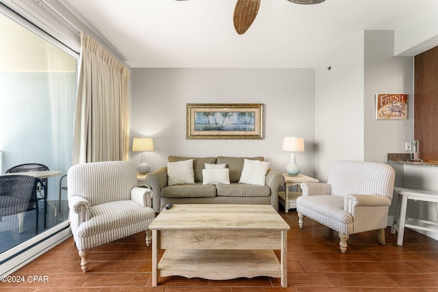 living room with wood finish floors, a baseboard heating unit, and a ceiling fan