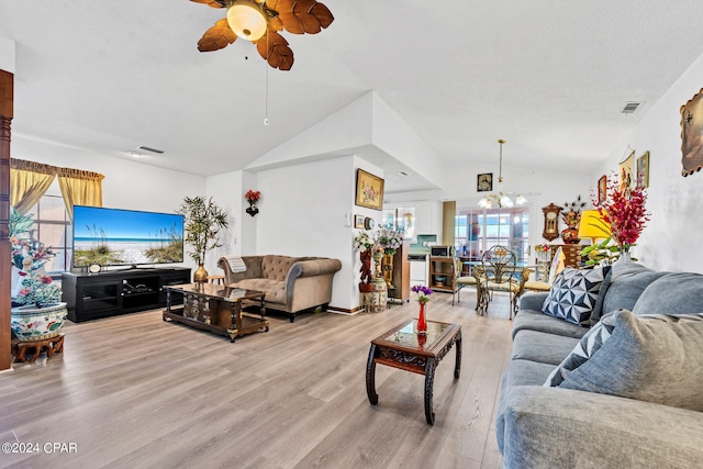 living room featuring light wood-type flooring, ceiling fan with notable chandelier, and vaulted ceiling