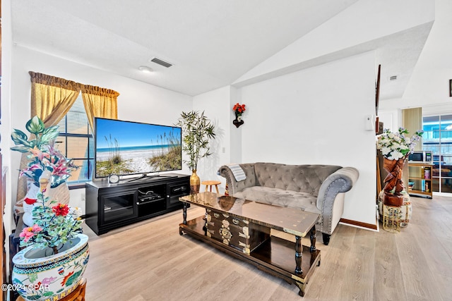 living room featuring light hardwood / wood-style flooring and vaulted ceiling