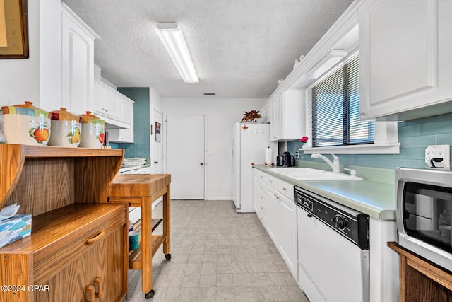 kitchen with white cabinets, a textured ceiling, sink, and white appliances