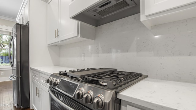 kitchen with stainless steel appliances, premium range hood, ornamental molding, white cabinets, and wood-type flooring