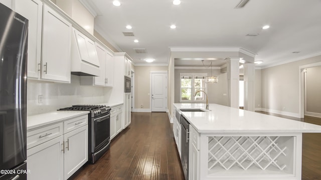 kitchen featuring sink, dark hardwood / wood-style flooring, ornate columns, and stainless steel appliances