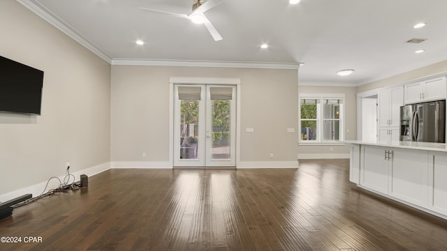 unfurnished living room with ceiling fan, a healthy amount of sunlight, ornamental molding, and wood-type flooring