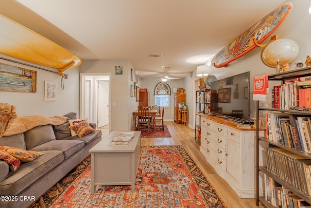 living room with ceiling fan and light hardwood / wood-style floors