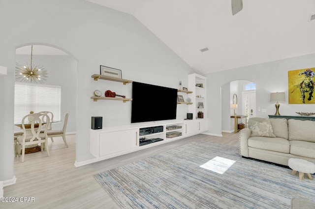 living room featuring built in shelves, light wood-type flooring, high vaulted ceiling, and an inviting chandelier