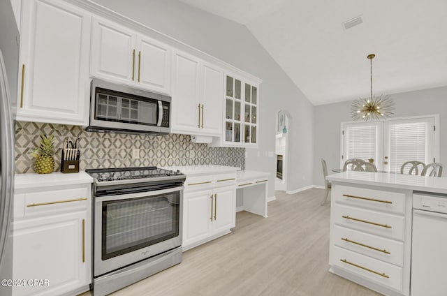 kitchen with backsplash, stainless steel appliances, and white cabinetry