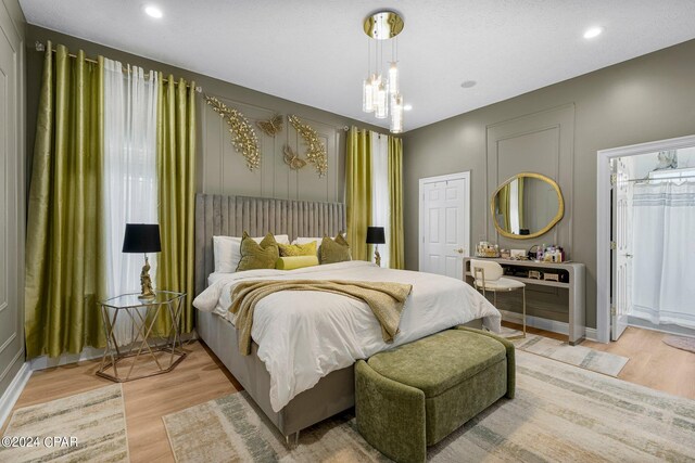 bedroom with a chandelier and light wood-type flooring