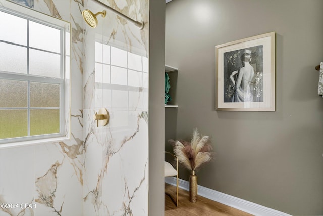 bathroom with hardwood / wood-style flooring and a shower