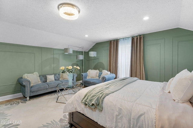 bedroom with lofted ceiling and a textured ceiling