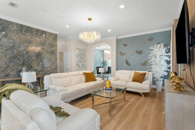 living room featuring ornamental molding, light wood-type flooring, tile walls, and a textured ceiling