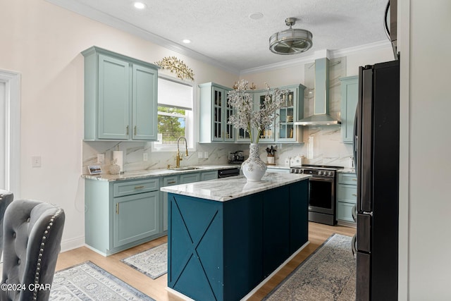 kitchen with wall chimney range hood, stainless steel range with electric stovetop, light hardwood / wood-style flooring, and black refrigerator