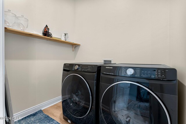 laundry room featuring hardwood / wood-style flooring and washing machine and clothes dryer