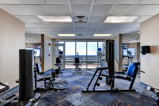 workout area with carpet floors and a paneled ceiling