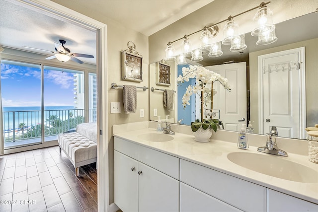 bathroom featuring vanity, ceiling fan, and a water view