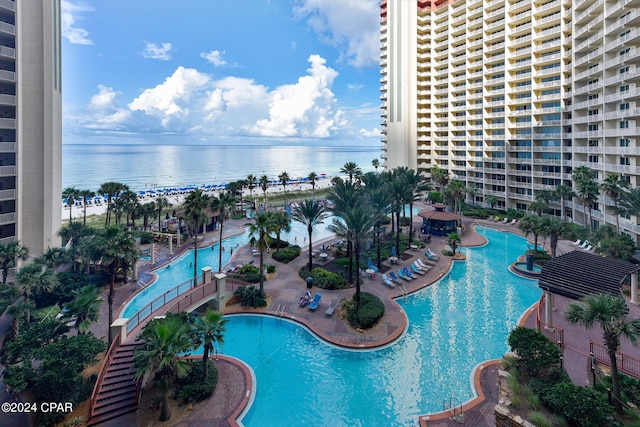 view of swimming pool featuring a patio and a water view