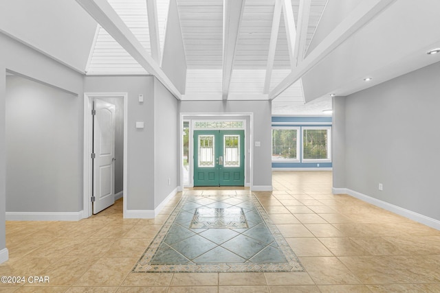 tiled foyer entrance with french doors, beamed ceiling, wooden ceiling, and high vaulted ceiling