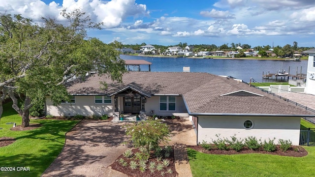 single story home with a front yard and a water view