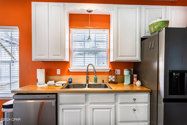 kitchen with white cabinetry, appliances with stainless steel finishes, wooden counters, and a sink