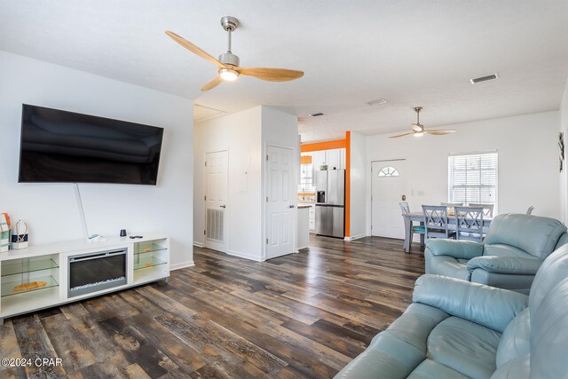 living room featuring ceiling fan and dark hardwood / wood-style floors